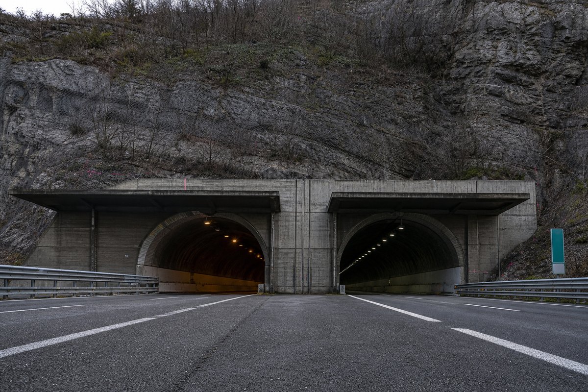 Motorway viaduct and tunnel portal in sequence along an autostrada in Italy: Apennine limestone ridge, twin concrete motorway portals with a projecting canopy. (AI-generated image)