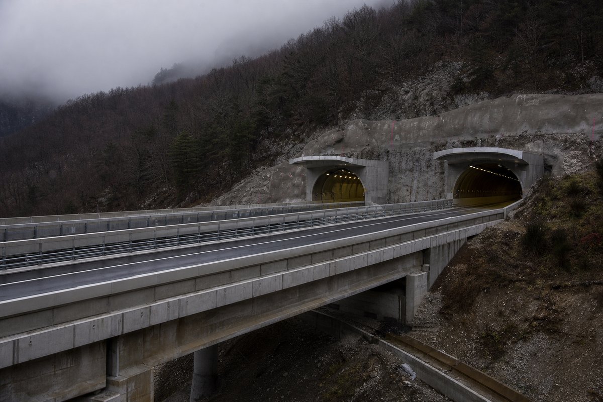 Motorway viaduct and tunnel portal in sequence along an autostrada in Italy: Apennine limestone ridge, twin concrete motorway portals with a projecting canopy. (AI-generated image)