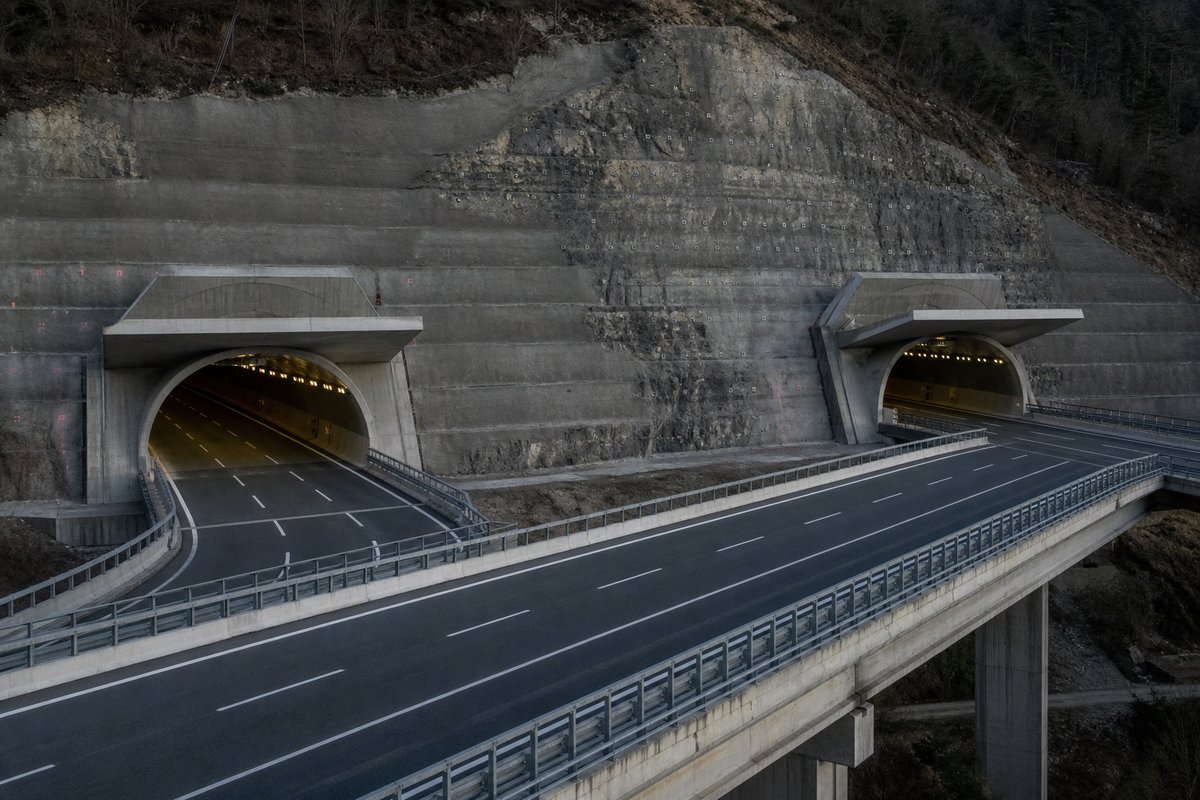Motorway viaduct and tunnel portal in sequence along an autostrada in Italy: Apennine limestone ridge, twin concrete motorway portals with a projecting canopy. (AI-generated image)