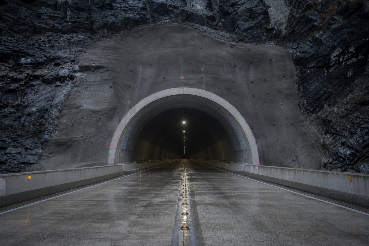 Road tunnel portal in Mexico: Sierra Madre canyon with a highway tunnel portal, after rain, everything wet and reflective, a dead-centre symmetrical composition. (AI-generated image)