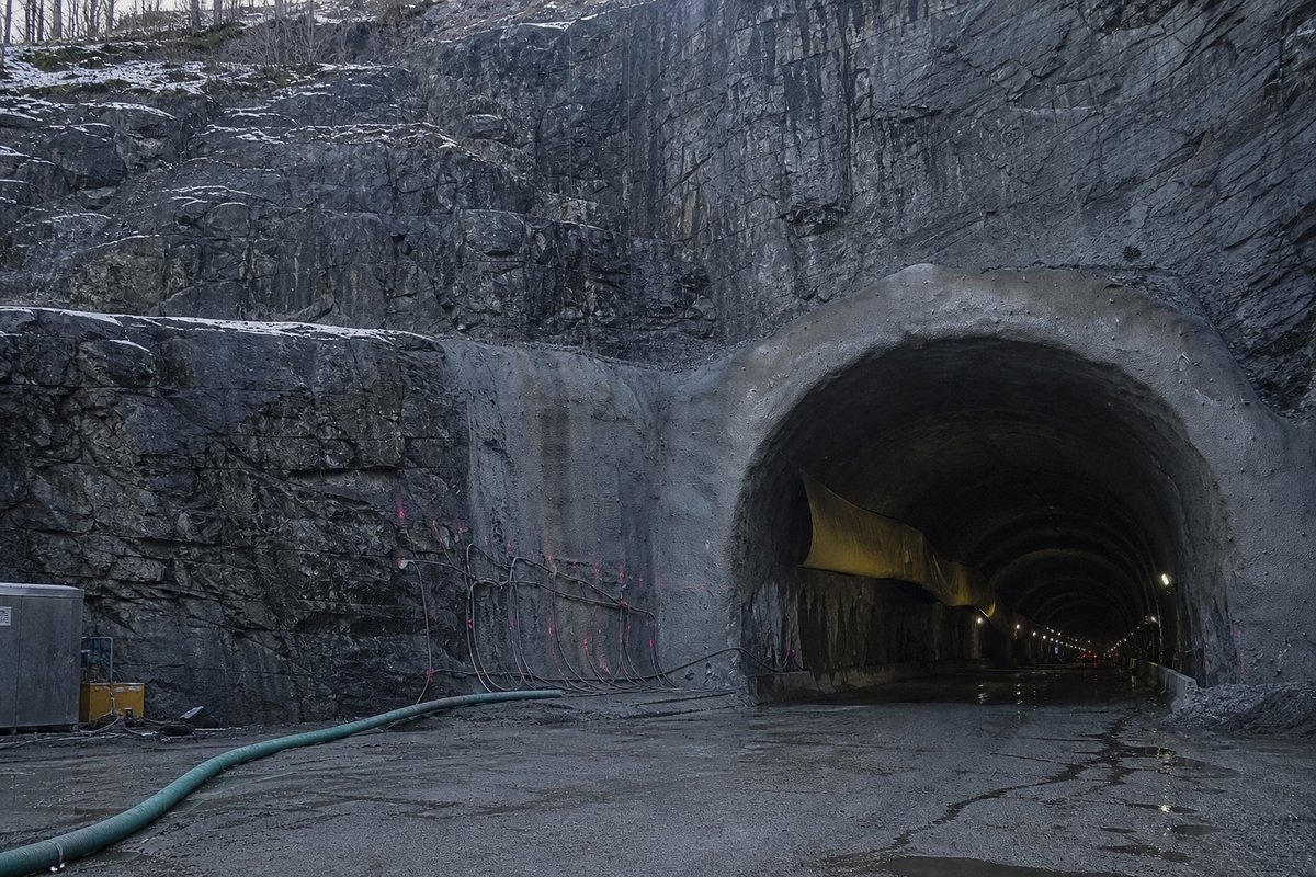 Transport infrastructure structure in Sweden: Scandinavian bedrock cutting with a blasted rock tunnel mouth, in hard low winter sun, shot at 35mm. (AI-generated image)