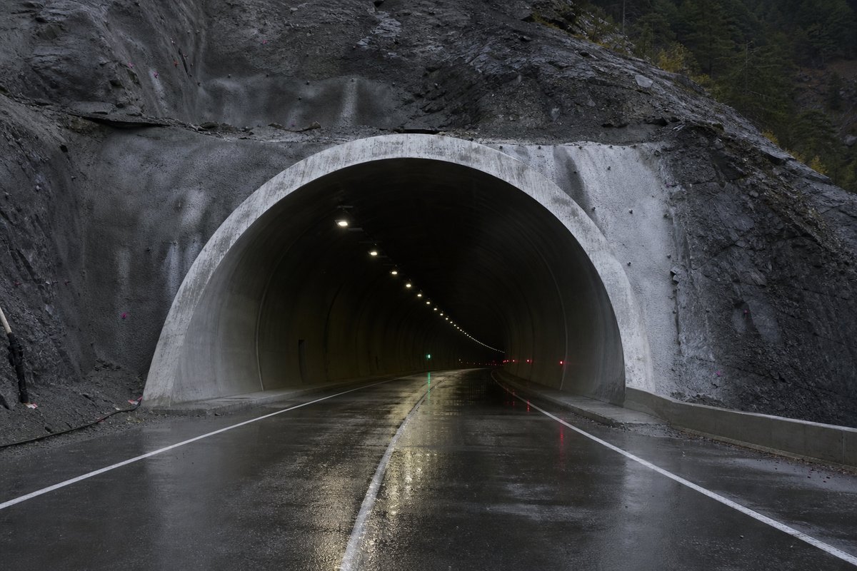 Road tunnel portal in Türkiye: Anatolian mountain pass with a long new road tunnel portal, after rain, everything wet and reflective, shot at 35mm. (AI-generated image)