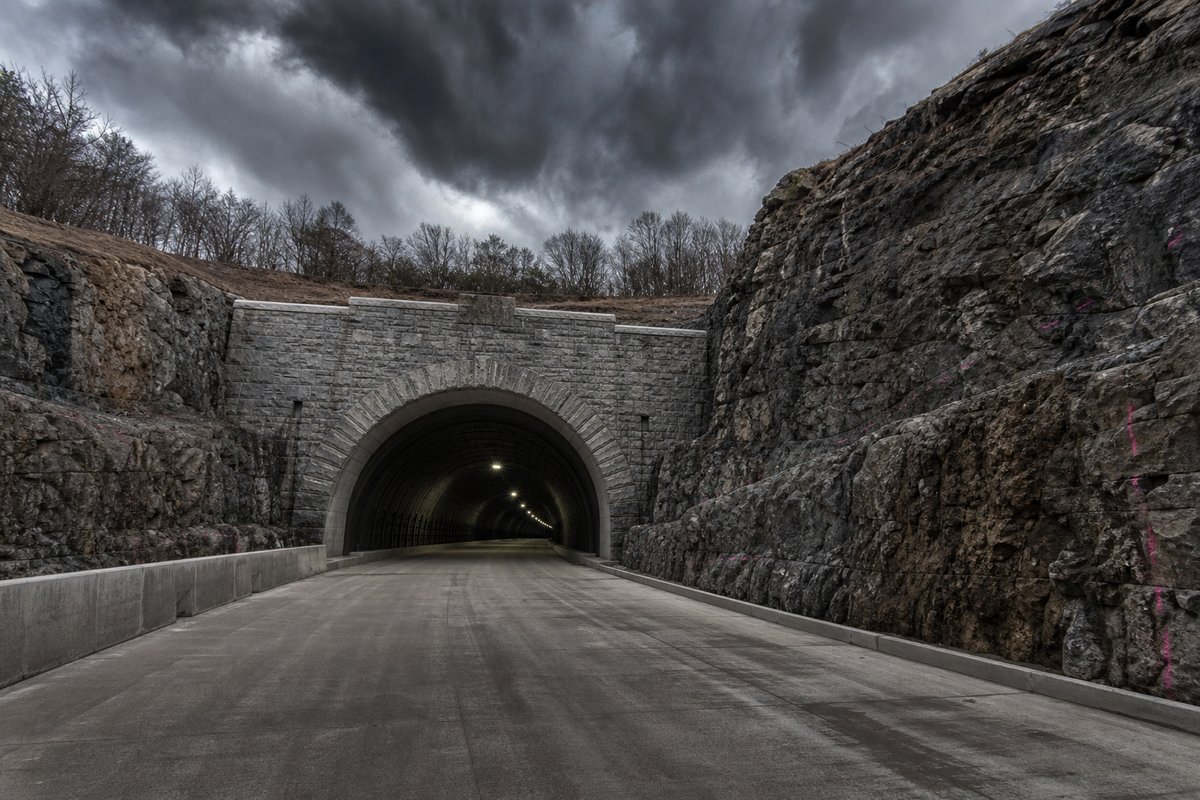 Transport infrastructure structure in the United States: a mountainous transport corridor, under a heavy dark sky, shot wide at 24mm. (AI-generated image)